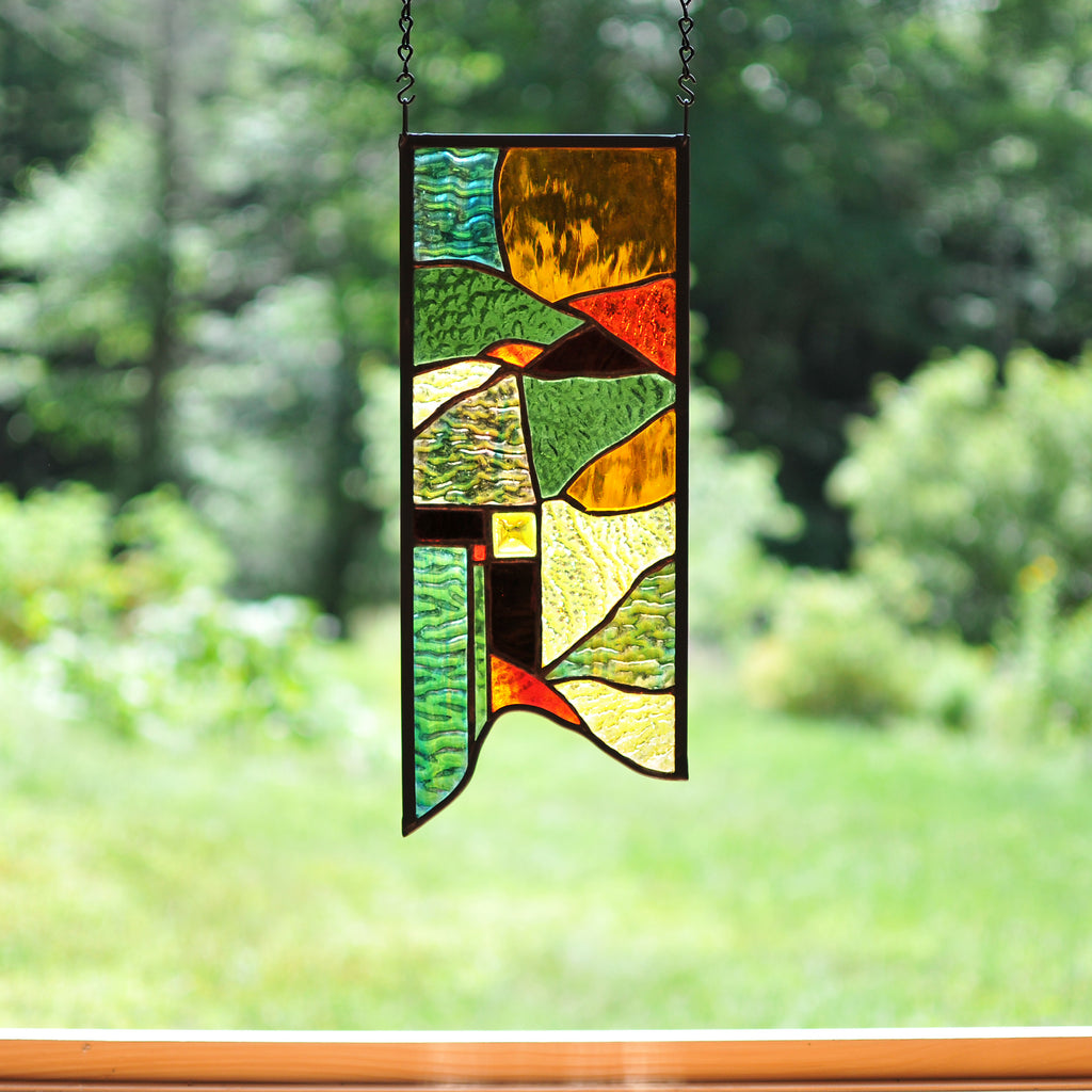 Small stained glass panel with nature inspired organic lines made by Vermont artist Julia Brandis. Organic abstract.